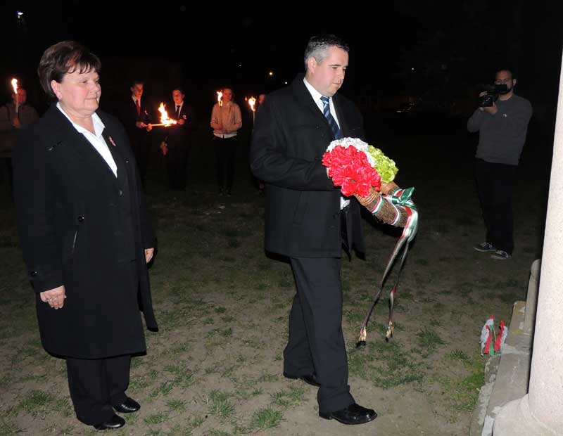 Csendesné Farkas Edit polgármester és Péter Zoltán alpolgármester megkoszorúzza az iskola előtti emlékművet